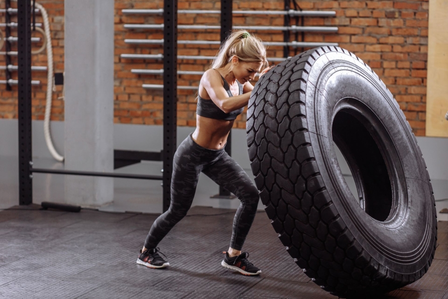 woman moving the big tyre